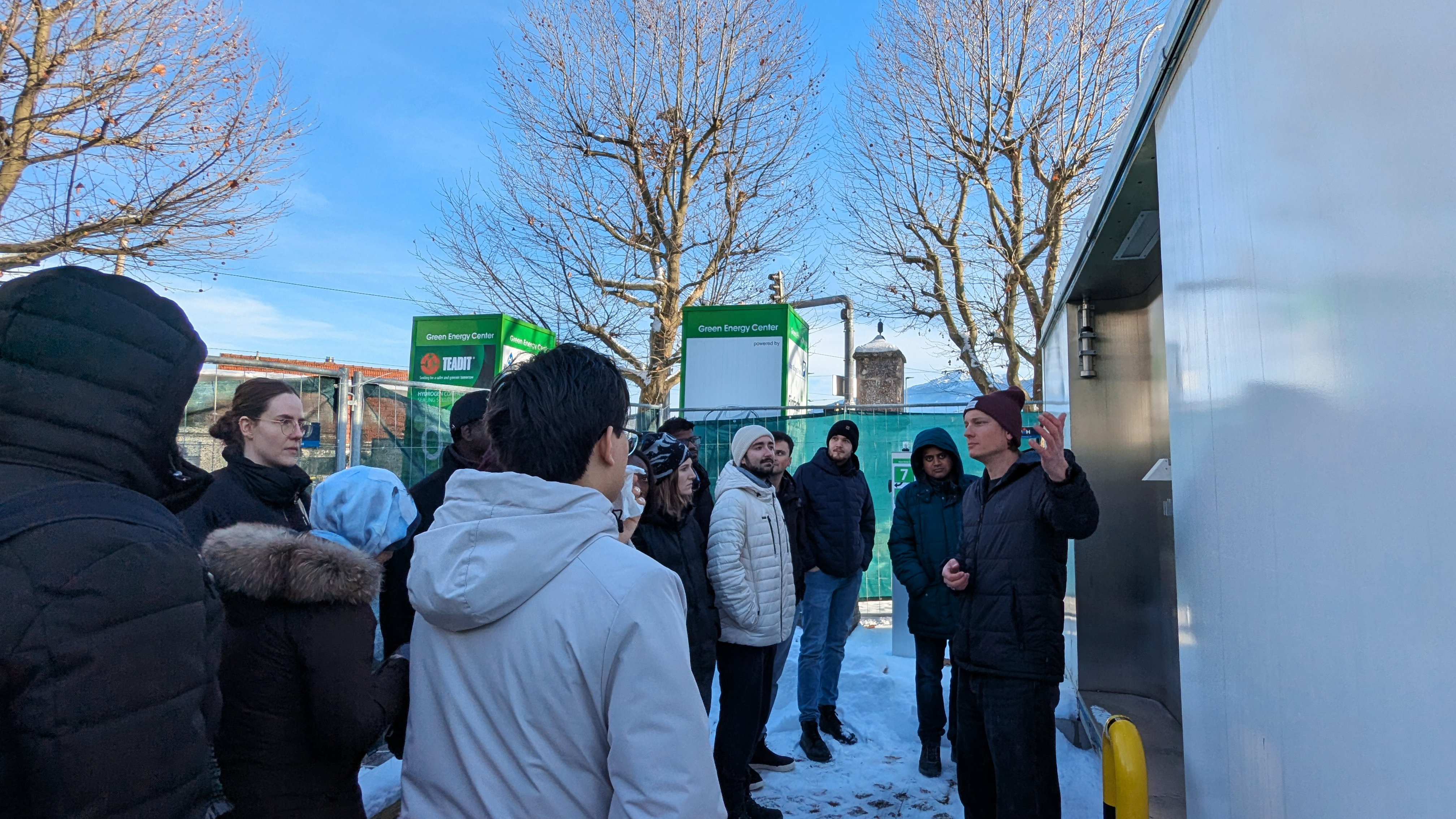 Students standing outside as Nicolas Fleischhacker explains green energy car charging